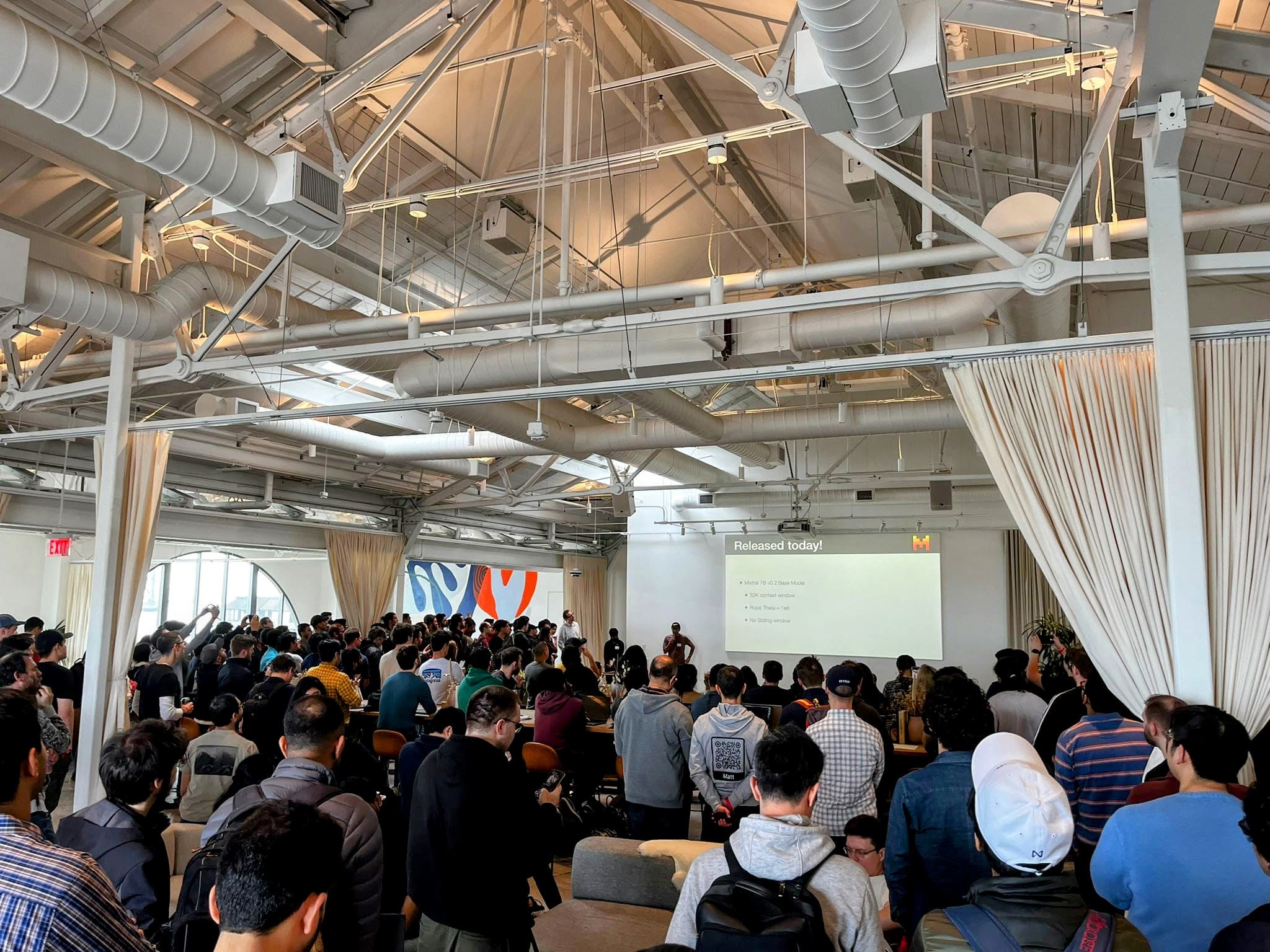 Packed venue at an AI community event with hundreds of attendees
